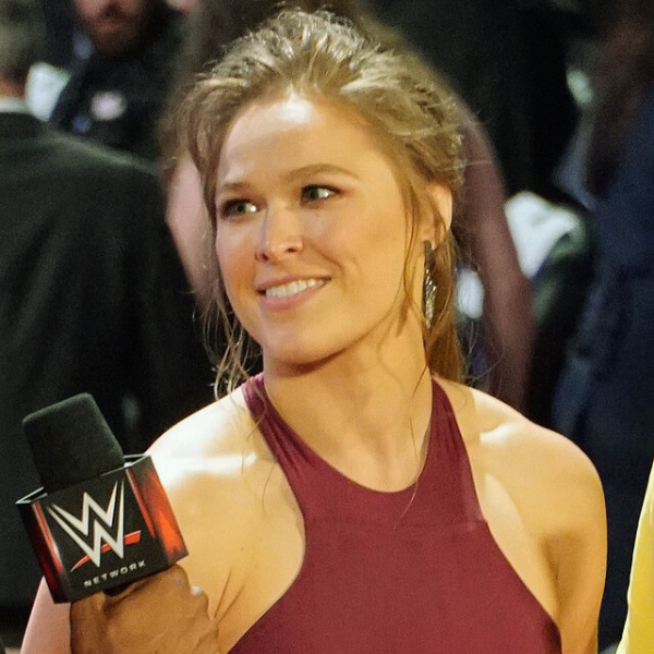 Ronda Rousey smiling confidently, symbolizing her journey from defeat to mental health recovery